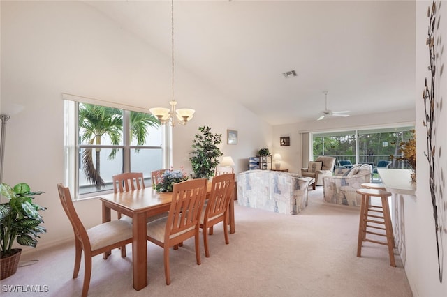 dining room with light carpet, ceiling fan with notable chandelier, and high vaulted ceiling