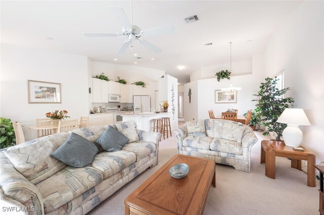 carpeted living room featuring ceiling fan