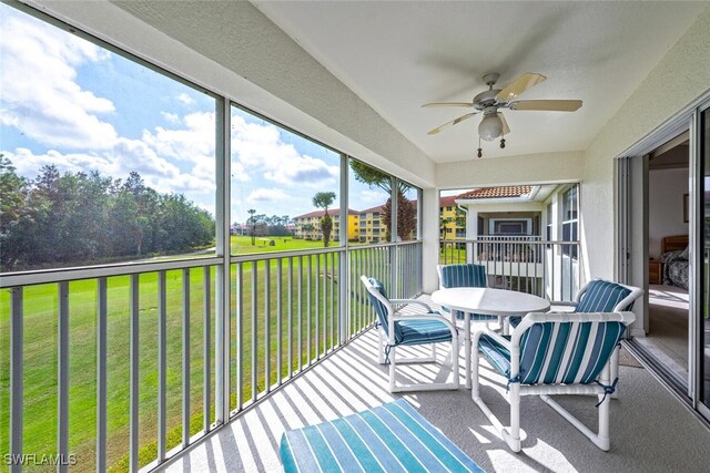 sunroom / solarium featuring ceiling fan