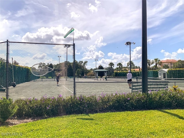 view of sport court with a yard