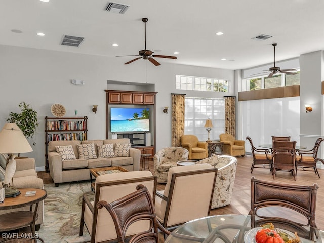 living room featuring light hardwood / wood-style flooring and ceiling fan