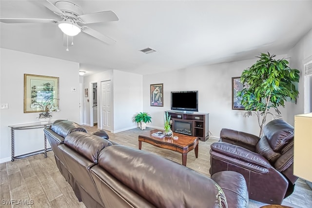 living room with ceiling fan and light wood-type flooring