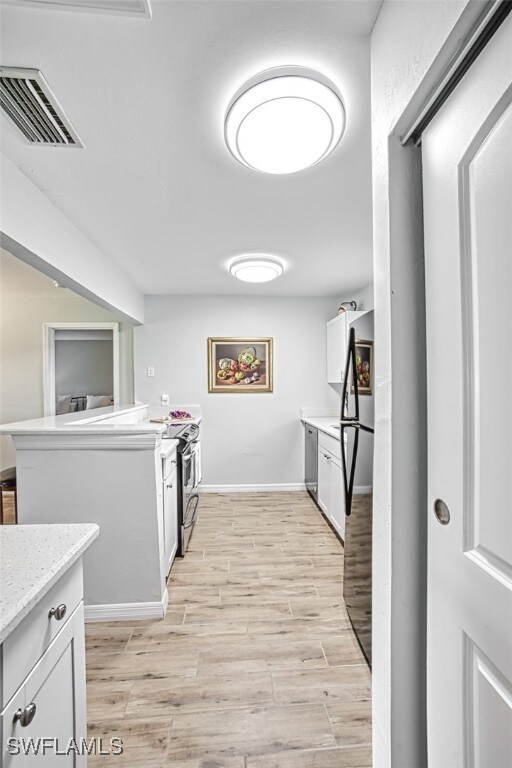 kitchen featuring white cabinetry, light hardwood / wood-style flooring, and stainless steel appliances