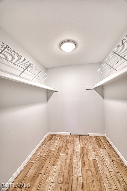 walk in closet with hardwood / wood-style floors