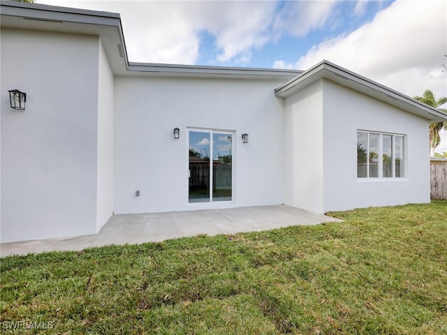 back of property featuring a patio and a lawn