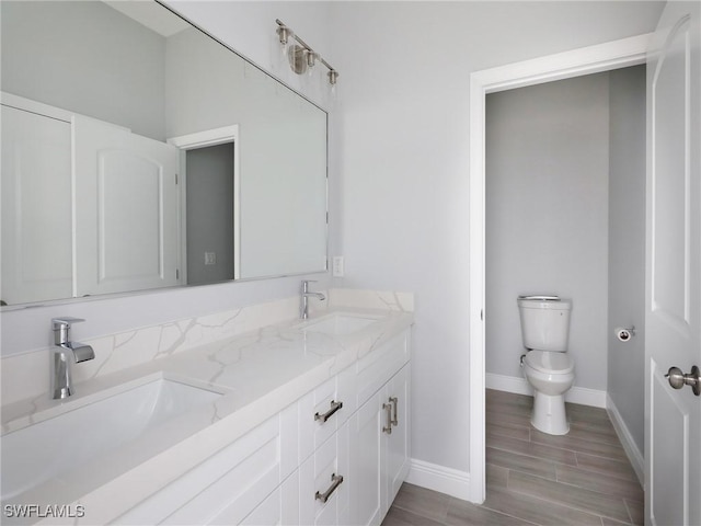 bathroom with vanity, hardwood / wood-style flooring, and toilet