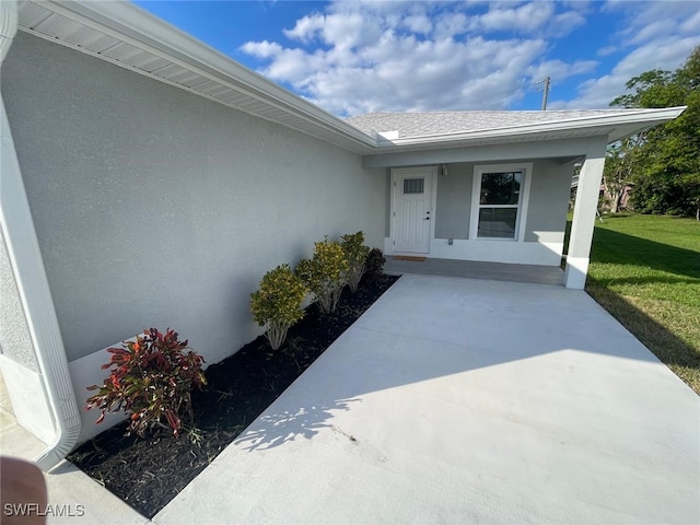 doorway to property with a lawn