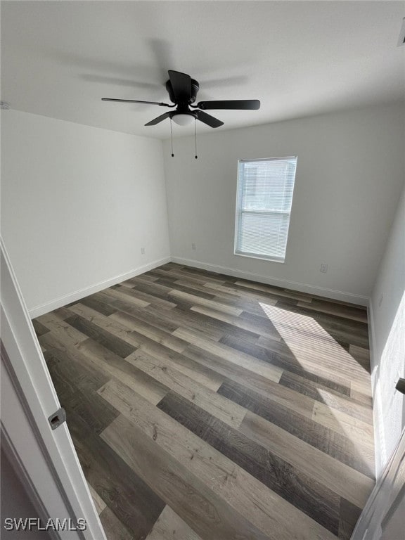 spare room with ceiling fan and dark wood-type flooring