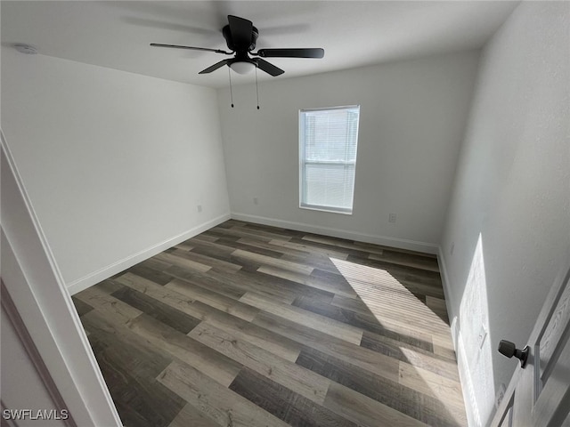 spare room featuring dark hardwood / wood-style floors and ceiling fan