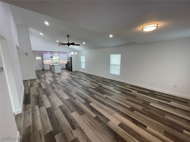 unfurnished living room featuring plenty of natural light, dark hardwood / wood-style floors, lofted ceiling, and ceiling fan