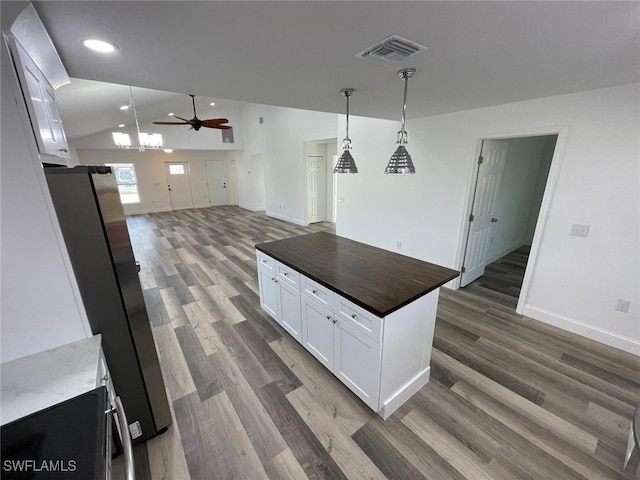 kitchen featuring white cabinets, dark hardwood / wood-style flooring, lofted ceiling, and hanging light fixtures