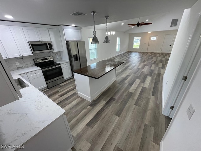 kitchen featuring ceiling fan, stainless steel appliances, dark hardwood / wood-style floors, vaulted ceiling, and white cabinets