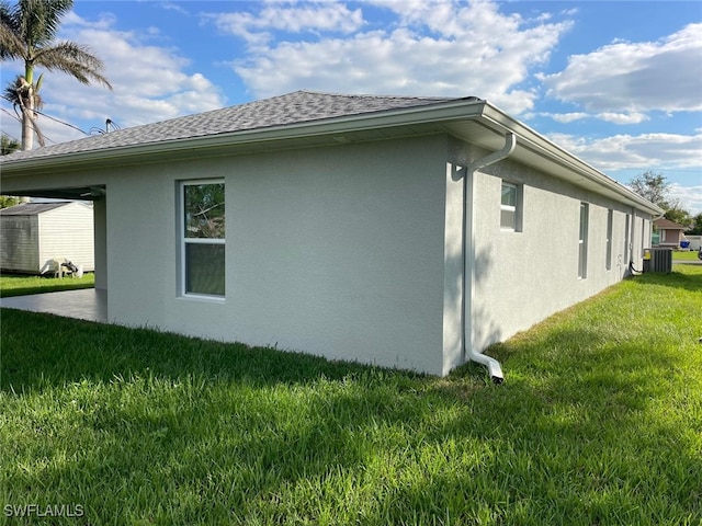 view of side of home with a lawn and central AC