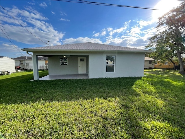 back of property with a patio area and a lawn