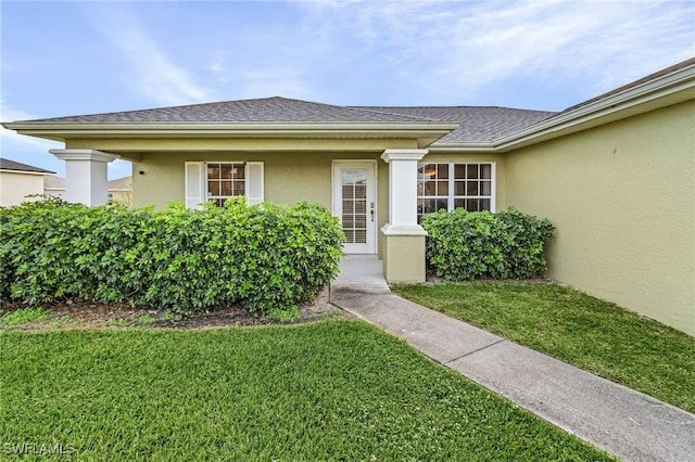 view of exterior entry with a yard