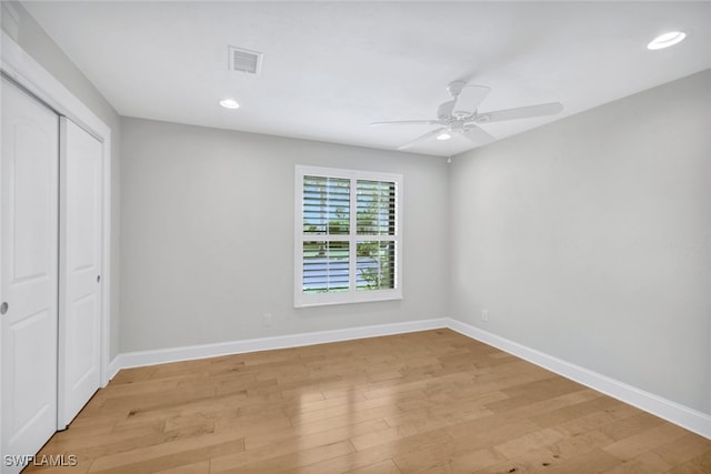 unfurnished bedroom featuring ceiling fan, light wood-type flooring, and a closet