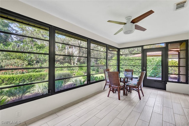 unfurnished sunroom with ceiling fan