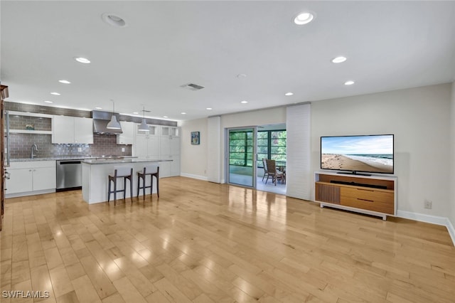 unfurnished living room with light wood-type flooring and sink