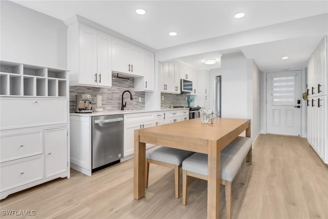 kitchen with white cabinetry, light hardwood / wood-style flooring, and stainless steel appliances