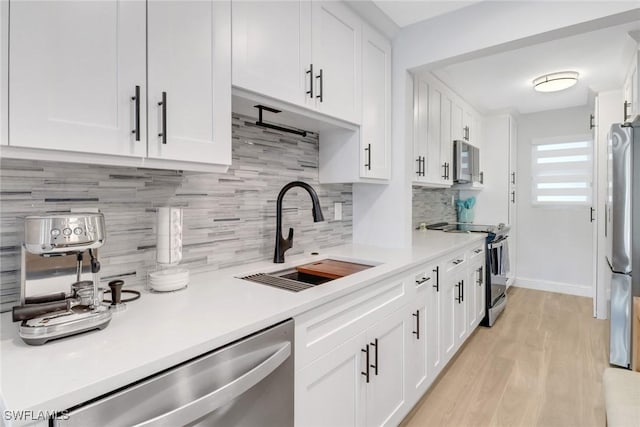 kitchen featuring white cabinets, appliances with stainless steel finishes, and sink