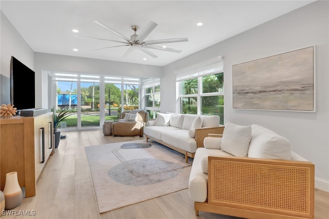 living room with ceiling fan, a wealth of natural light, and light hardwood / wood-style flooring