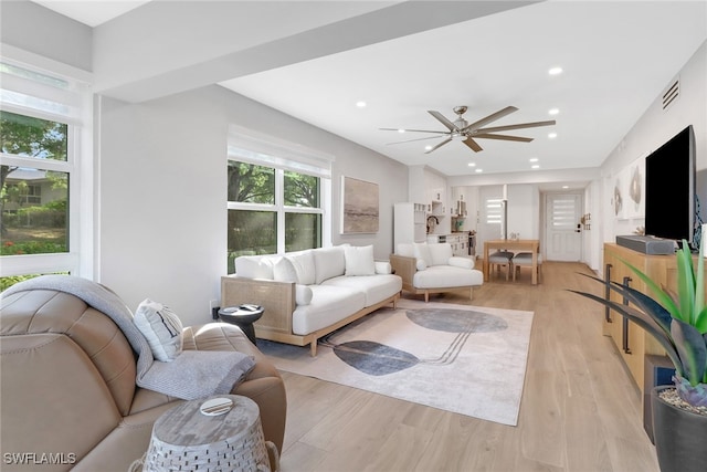 living room with light hardwood / wood-style floors and ceiling fan