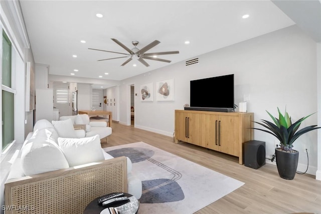 living room featuring light wood-type flooring and ceiling fan