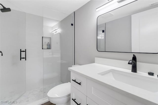 bathroom with vanity, toilet, and a shower with shower door