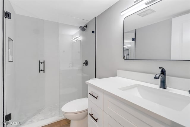 bathroom featuring vanity, an enclosed shower, and toilet