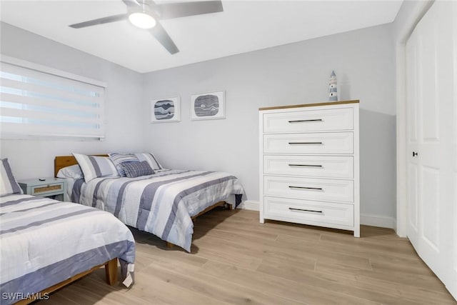 bedroom with a closet, light hardwood / wood-style floors, and ceiling fan