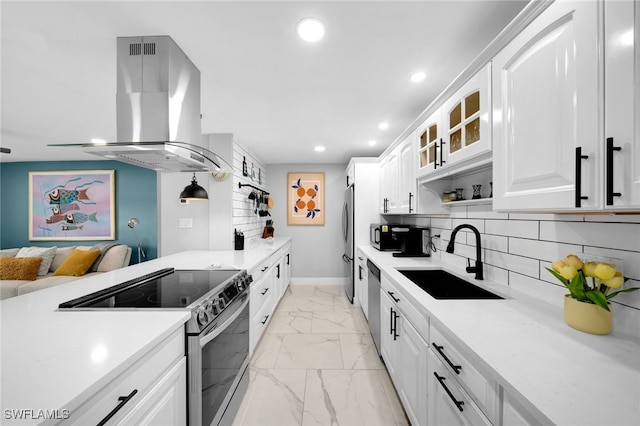 kitchen featuring backsplash, island range hood, stainless steel appliances, sink, and white cabinets