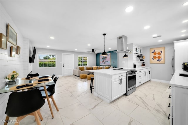 kitchen featuring pendant lighting, white cabinets, ceiling fan, stainless steel electric range oven, and range hood