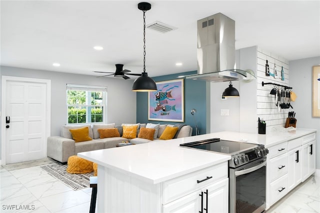 kitchen featuring island exhaust hood, ceiling fan, decorative light fixtures, white cabinetry, and stainless steel range with electric cooktop