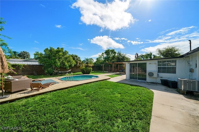 view of yard featuring ac unit, a patio, a fenced in pool, and central AC