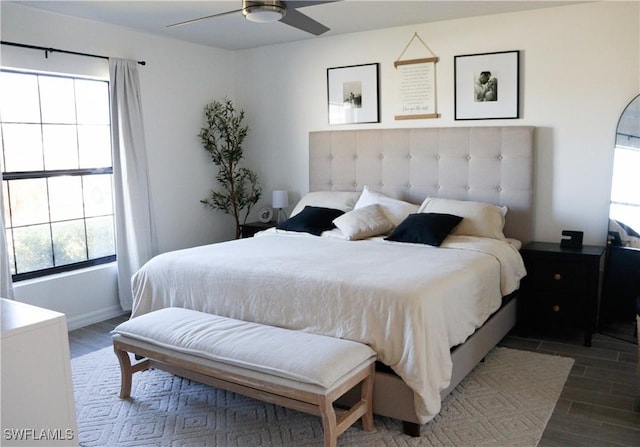 bedroom featuring multiple windows, ceiling fan, and dark hardwood / wood-style floors