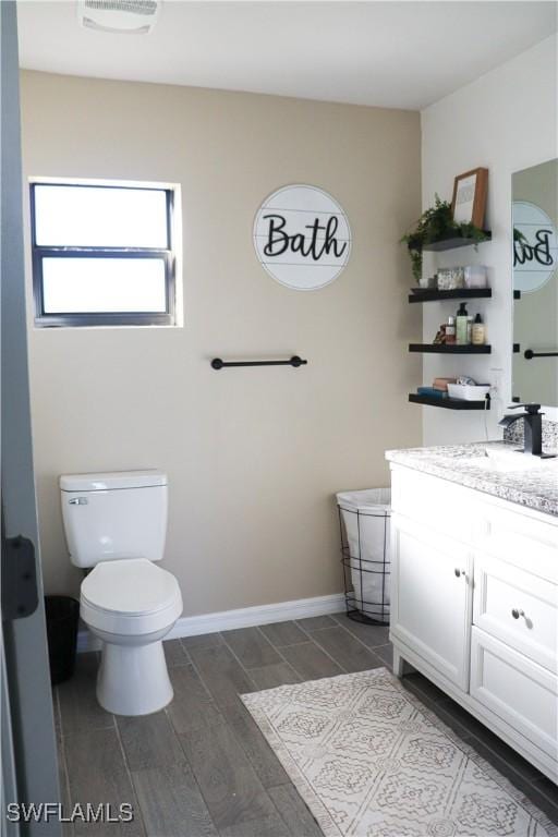 bathroom featuring vanity, wood-type flooring, and toilet