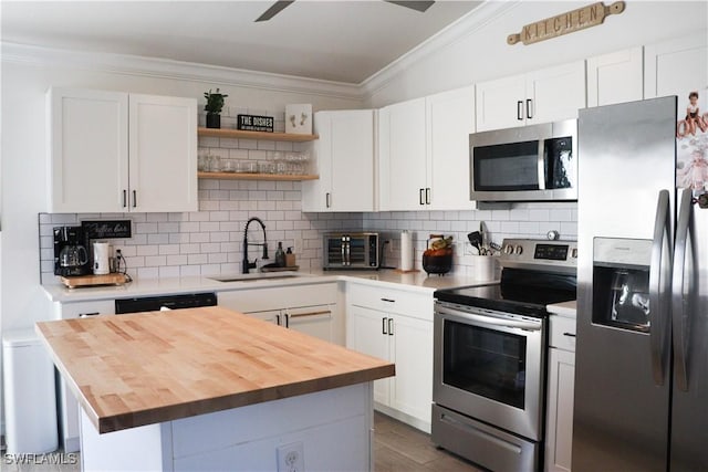 kitchen with white cabinets, appliances with stainless steel finishes, decorative backsplash, and sink