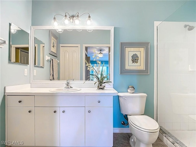 bathroom with tile patterned floors, toilet, vanity, and a tile shower