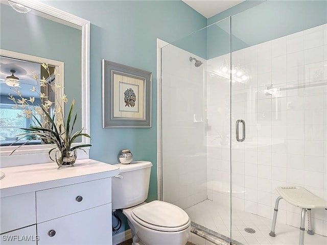 bathroom featuring a shower with door and toilet