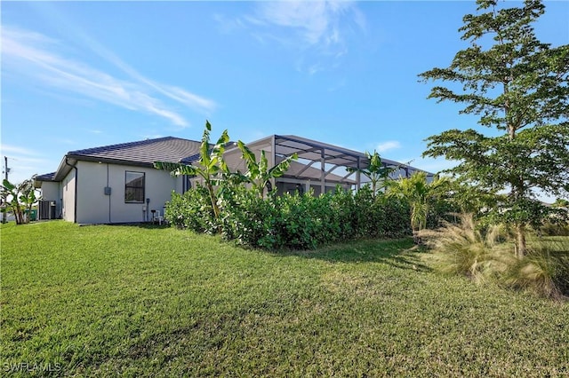 view of yard with a lanai and central air condition unit