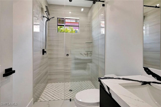 bathroom with vanity, toilet, and a shower with door