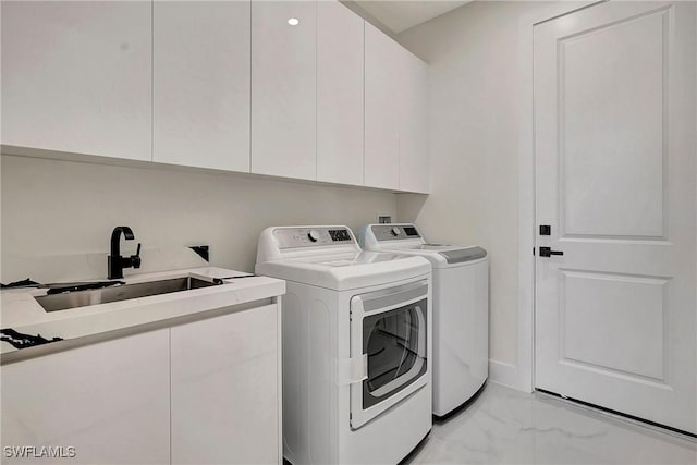 laundry room featuring cabinets, separate washer and dryer, and sink