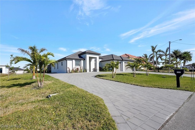 3307 NW 3rd St, Cape Coral, FL 33993 - view of front of home featuring a garage, a front lawn, decorative driveway, and stucco siding