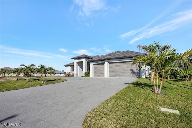 3307 NW 3rd St, Cape Coral, FL 33993 - prairie-style home featuring driveway, an attached garage, a front lawn, and stucco siding