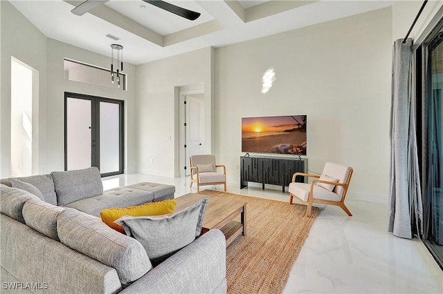 living room with ceiling fan, a towering ceiling, and coffered ceiling