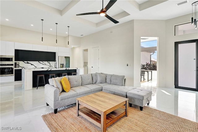 living room featuring ceiling fan, beamed ceiling, a towering ceiling, and coffered ceiling