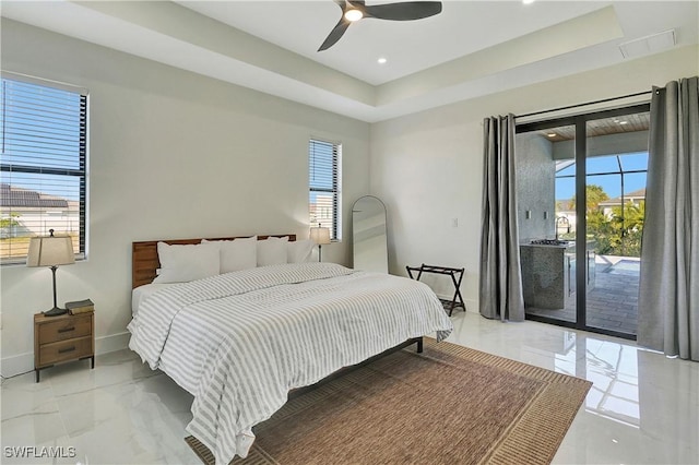 bedroom featuring a raised ceiling, access to exterior, and ceiling fan