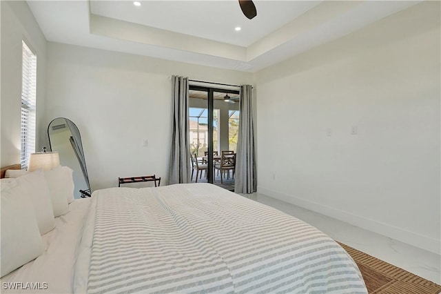 bedroom featuring a tray ceiling, access to exterior, and ceiling fan