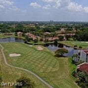 aerial view with golf course view and a water view