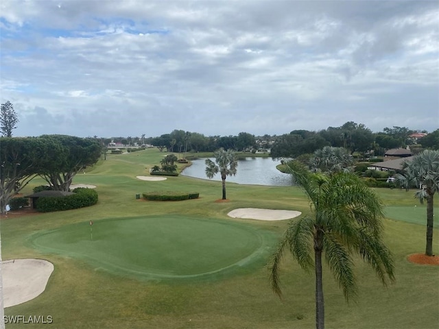 view of home's community with a water view, golf course view, and a lawn